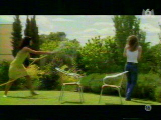 Two girls playing with a waterhose.